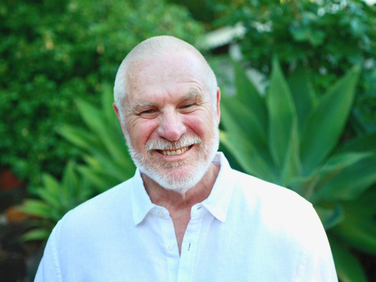 Vishrant smiling into camera with green nature background