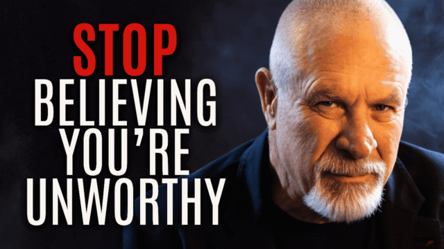 Close-up portrait of an older bald man with a trimmed white beard, gazing directly at the viewer with calm intensity. He wears a dark jacket against a softly lit, smoky background of deep blue and black tones. Bold red and white text reads: “STOP BELIEVING YOU’RE UNWORTHY.” The image conveys strength, awakening, and a call to self-worth.